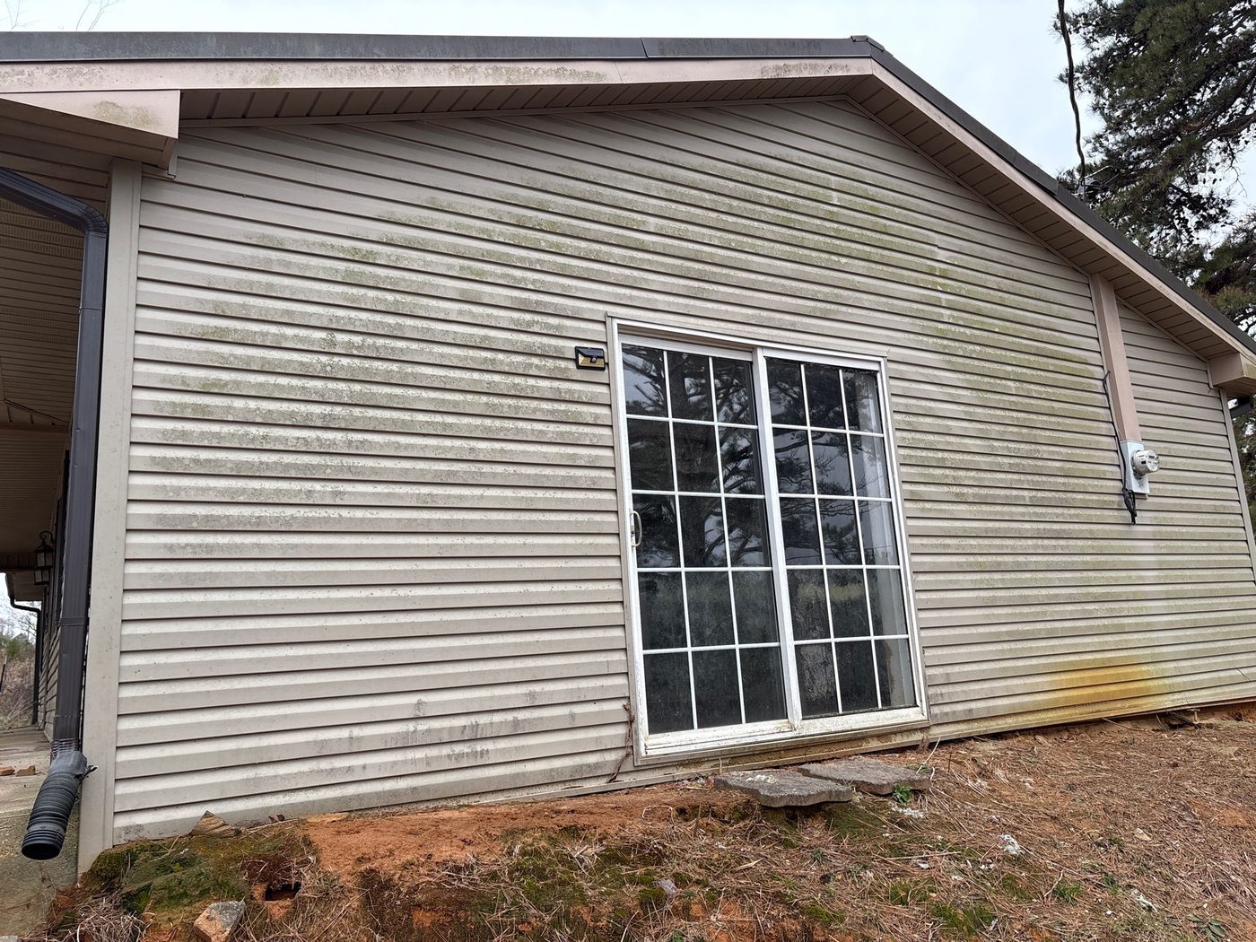 Home exterior with electric meter and outdoor lighting hardware
