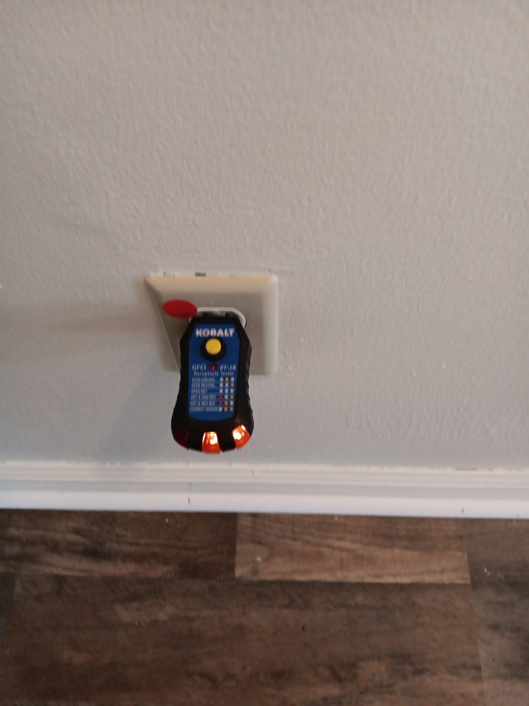 Outlet tester plugged into a wall receptacle during a safety check